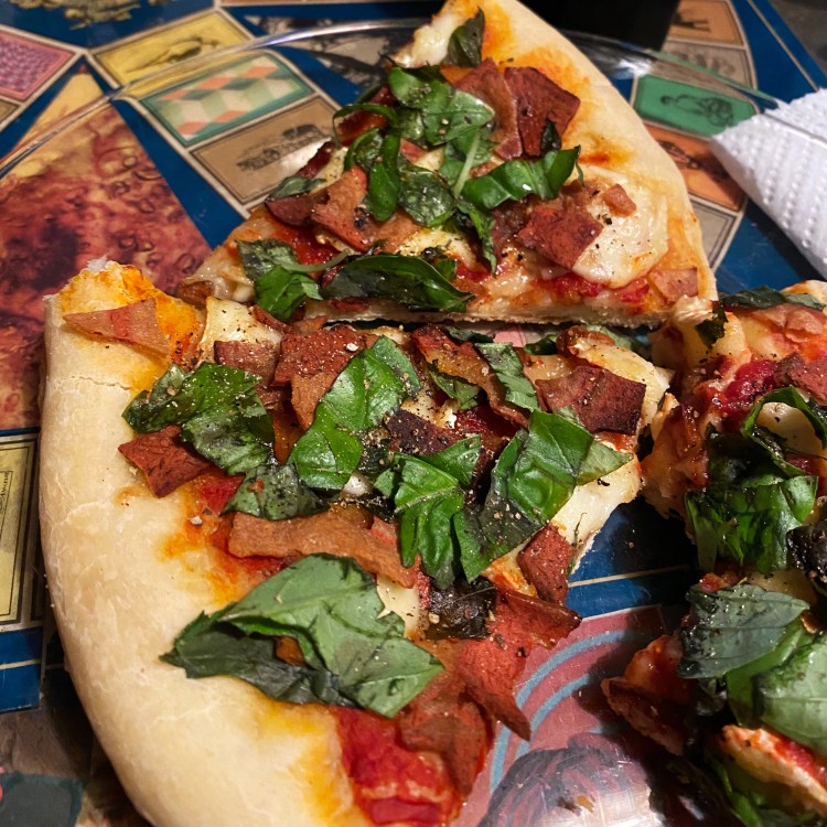 three pizza slices on a plate with toppings listed in caption