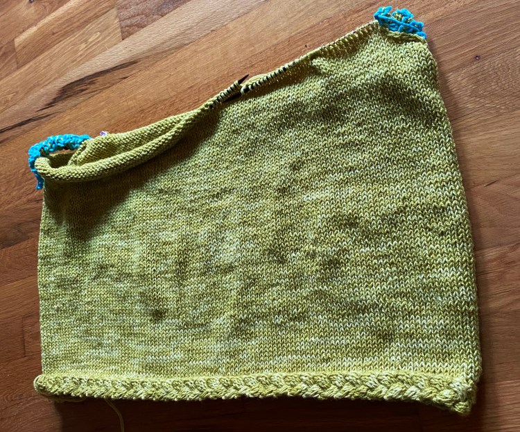 in-progress sweater body, with crochet-chain provisional stitches where the sleeves will go