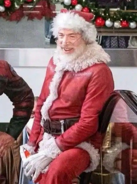 JK Simmons dressed as Santa wearing a hat with white fur trim