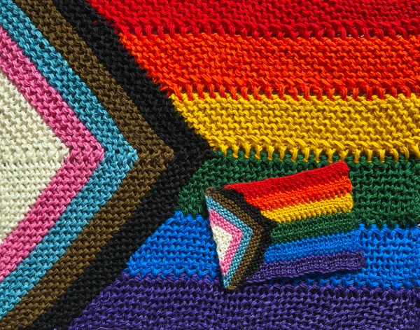 two different sizes of Progress knit flags stacked up