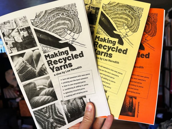 three copies of Remixed zine being held up, with white, yellow, and orange covers