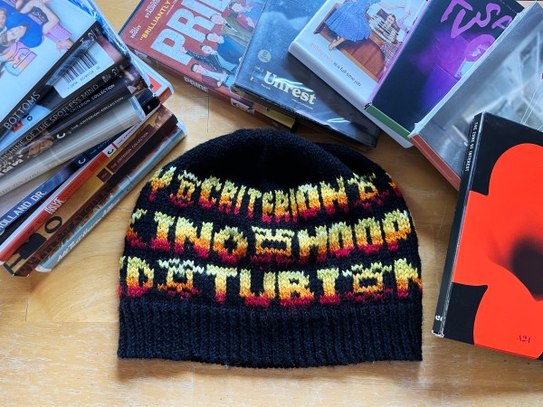hat with words on it laying flat amongst related items (blu rays and dvds)—visible words are CRITERION, KINO, TUBI